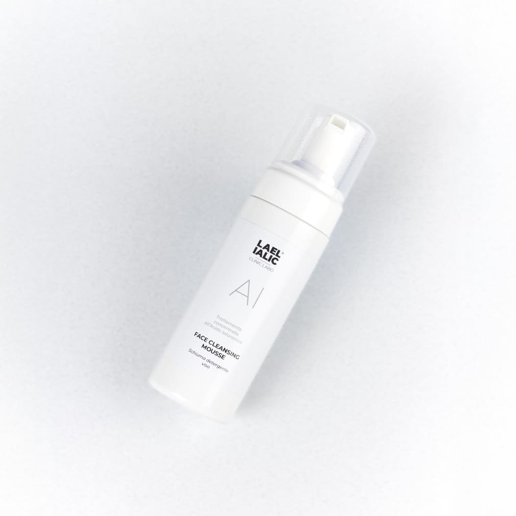 Flacone di schiuma detergente viso "AI" di Lael Ialic, con tappo trasparente e etichetta visibile, su sfondo neutro.